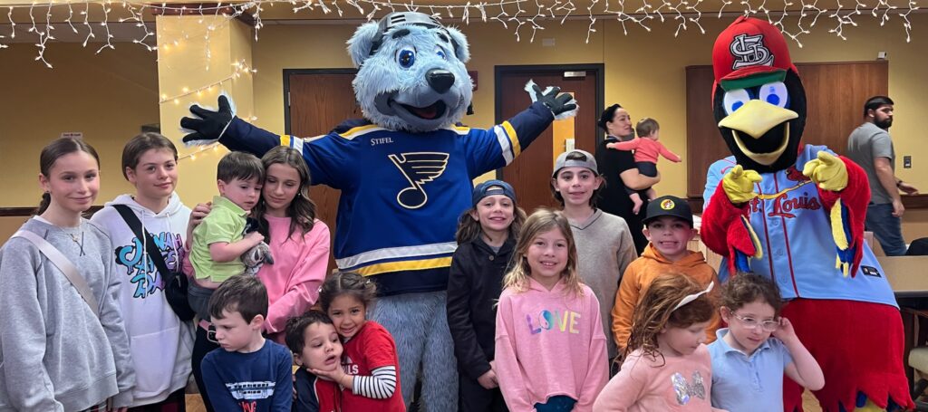 Several children, ages 3 through 10, pose with Fredbird and Louie from the St. Louis Cardinals and Blues.