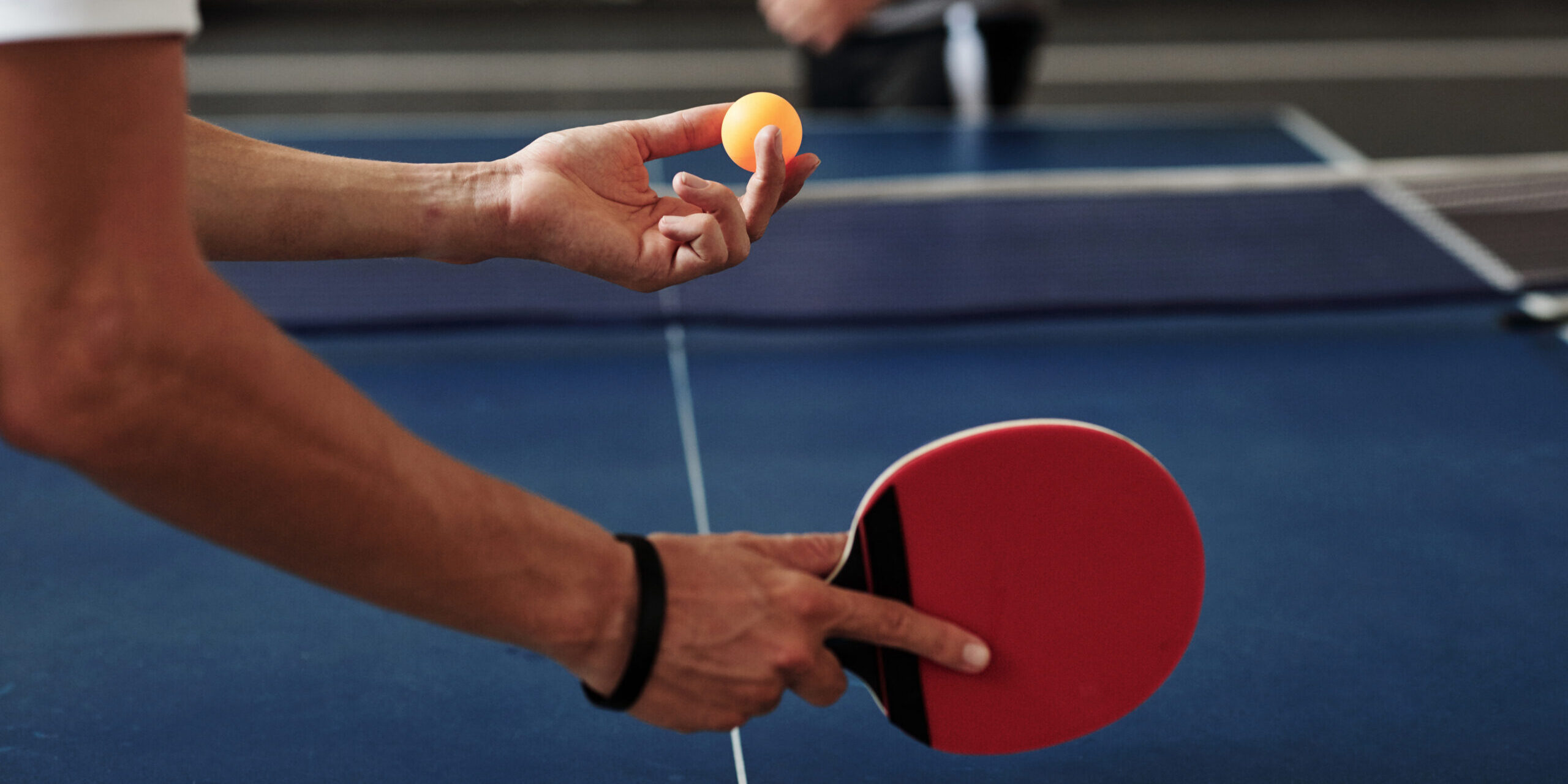 Close up of the hands of a man Serving Ping-Pong Ball
